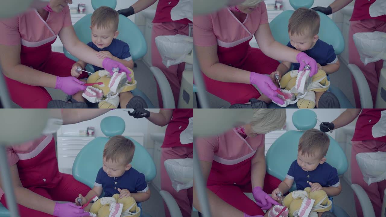 牙医诊所里可爱的小男孩。医生教小病人用下巴模拟刷牙。