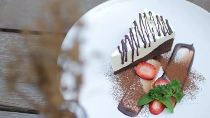木制桌子上有草莓的白巧克力蛋糕