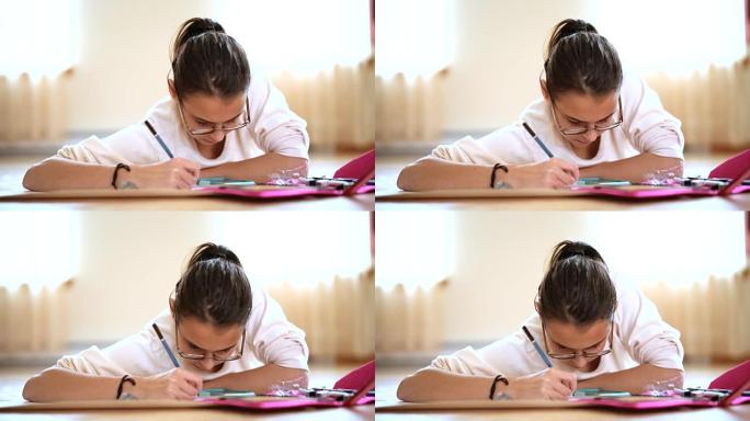 十几岁的女孩在学校做作业，躺在客厅的地板上