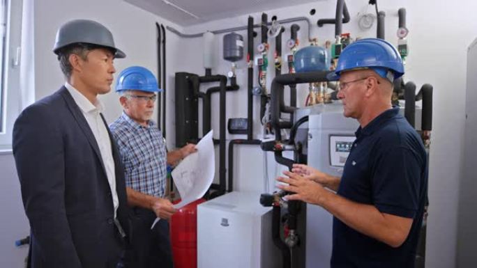 供暖技术人员向男业主解释新安装集中供暖的主要内容
