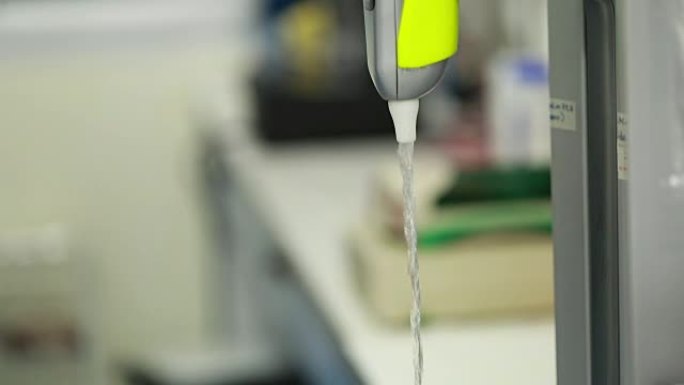 科学家从实验室的机器中获取去离子水，慢动作