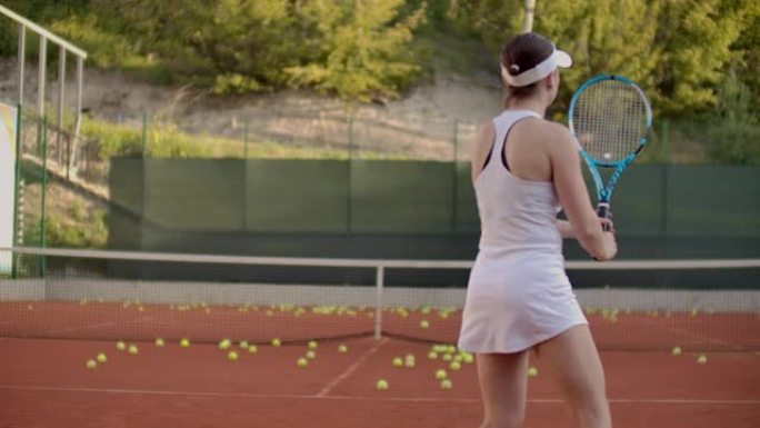 女子网球运动员在球场上打出飞球，是网球在公开球场上的动态比赛。