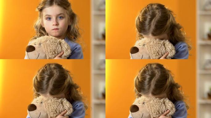 可爱的害羞学龄前女孩在泰迪熊藏脸，童年心理学