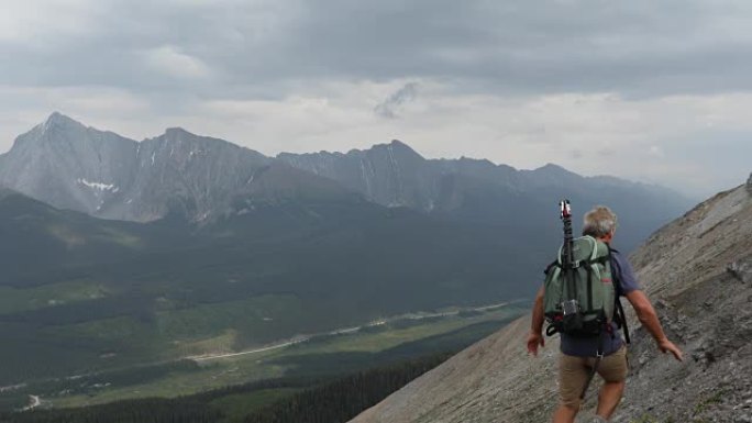 男性登山者穿越山谷上方的山面