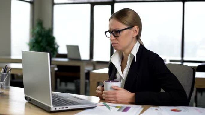 无聊的女人在办公室喝咖啡休息，对工作不满意，缺乏想法