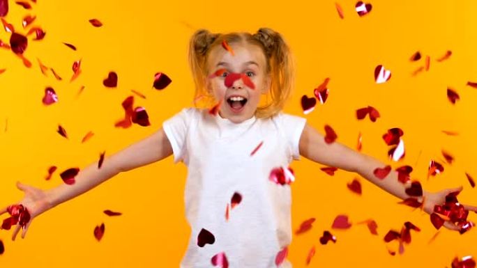 兴奋的女孩向空中投掷心形五彩纸屑，儿童派对，慢动作