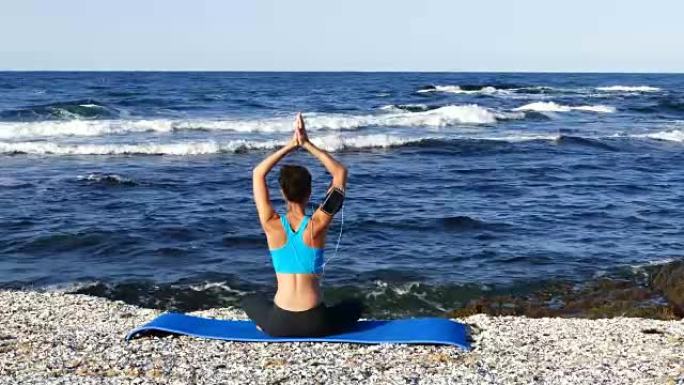 4k年轻女子在海滩上练习瑜伽