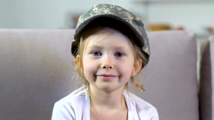 可爱的女孩戴着军帽在镜头前看近景，爱国民族，和平