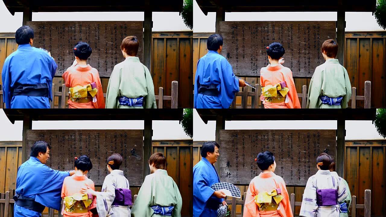 四个穿着和服的日本人观看布告板