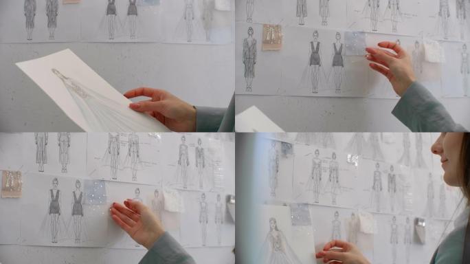 女时装设计师正在为她的最新系列选择并悬挂服装素描。轻质织物。女时装设计师正在选择