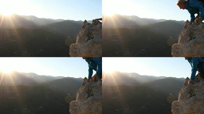 男性徒步旅行者在日出时达到悬崖峰顶