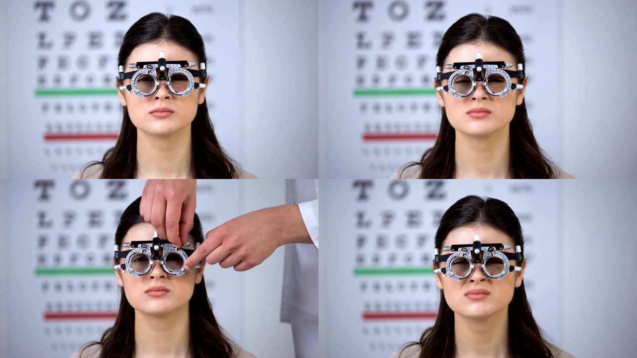 医生为病人在光学试验架上选择镜片，女士摇头