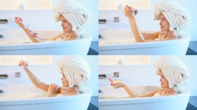 4k镜头特写女性在浴缸里洗澡玩泡泡。