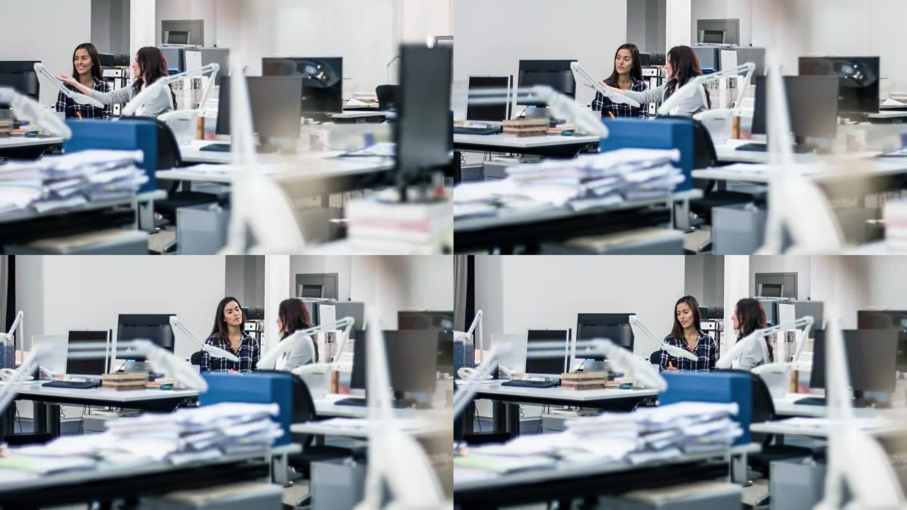 两名工业设计师女性在办公室讨论项目