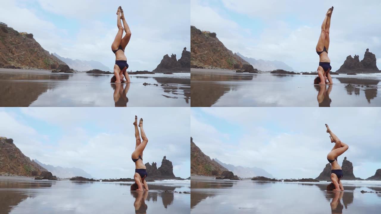 站在海洋上的体育女孩在空中移动她的腿
