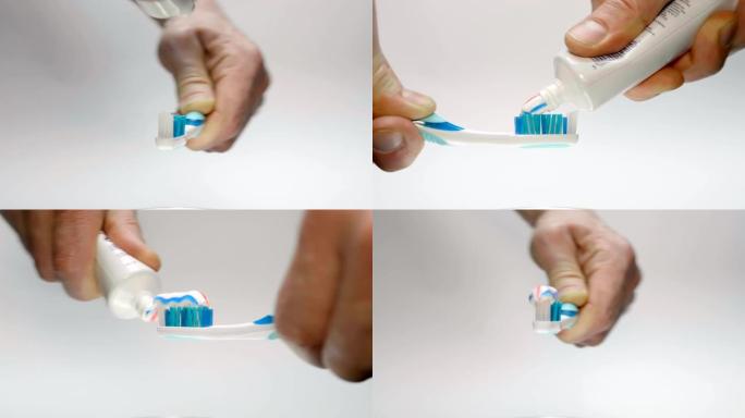 一名男子将牙膏从管子上挤在白色背上的蓝色牙刷上