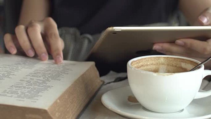 咖啡馆里有数字平板电脑和阅读书的女人