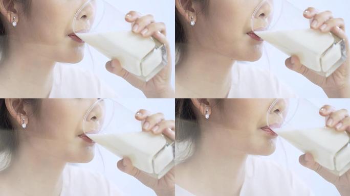 亚洲妇女正在喝一杯牛奶