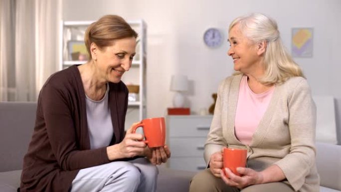老年女性朋友坐在舒适的客厅里喝茶聊天