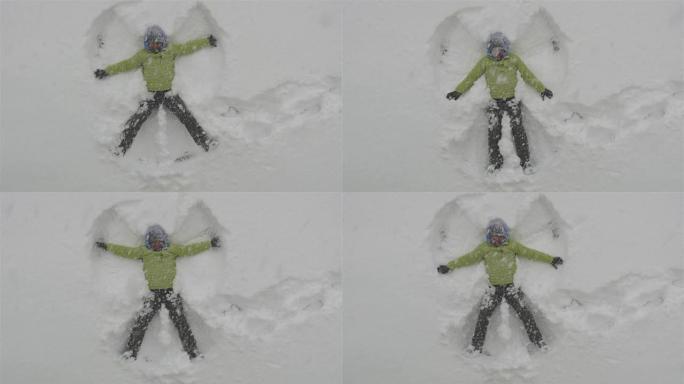 成年男子躺在新鲜的雪中，让雪天使玩得开心