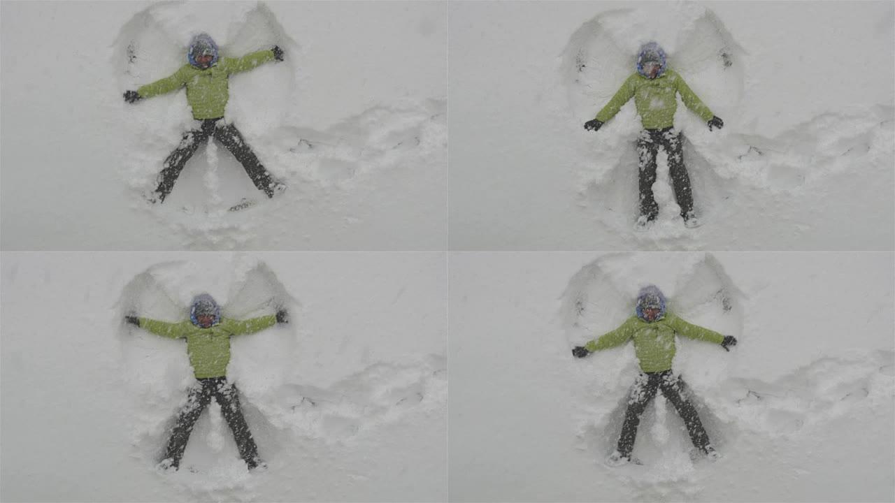 成年男子躺在新鲜的雪中，让雪天使玩得开心