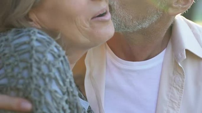 60多岁的男人在浪漫的户外约会中拥抱并亲吻他美丽的妻子