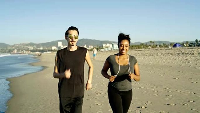 拉丁美洲人的生活方式。年轻夫妇，真正的人，有规律的，而不是肌肉发达的身体，清晨一起在海滩上慢跑。