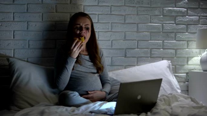 极度情绪化的孕妇哭着吃甜甜圈看情节剧