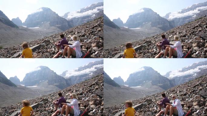 徒步旅行者家庭在高山岩石上放松
