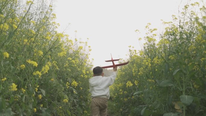 小男孩拿着飞机模型田间奔跑欢乐童年儿童节