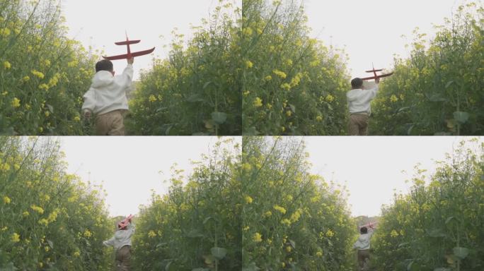 小男孩拿着飞机模型田间奔跑欢乐童年儿童节