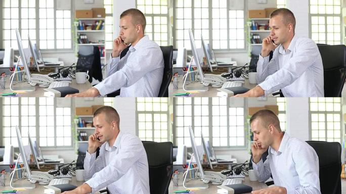 高清微笑的男人在工作场所用智能手机聊天