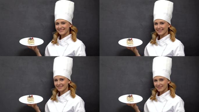迷人的女厨师在盘子，烹饪和面包店上展示开胃的蛋糕