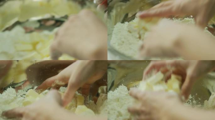 一名年轻女子的手将黄油块切成面粉 (切成小块并混合)，在金属搅拌碗中制成面团
