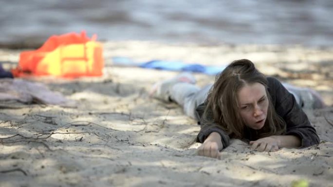 女人咳嗽呼吸困难，沉船后躺在海滩上，寻求帮助