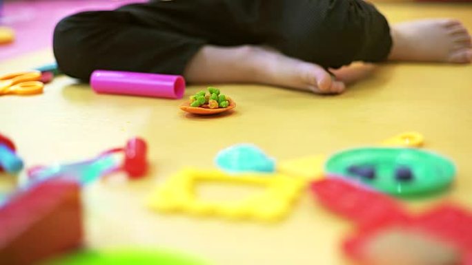 年轻的高加索儿童在玩面团的室内肖像，专注于他的手。