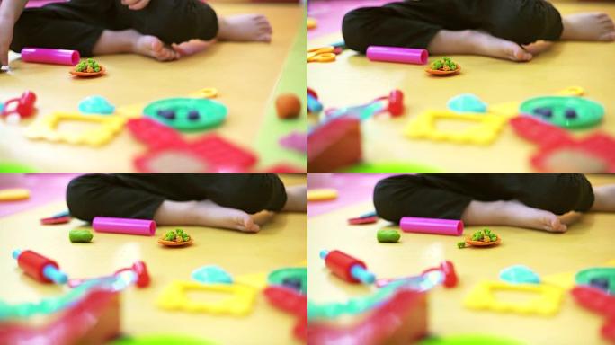 年轻的高加索儿童在玩面团的室内肖像，专注于他的手。