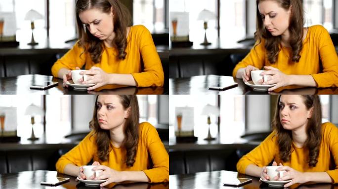沮丧的女人坐在咖啡馆里，检查智能手机，等待心爱的人打来的电话