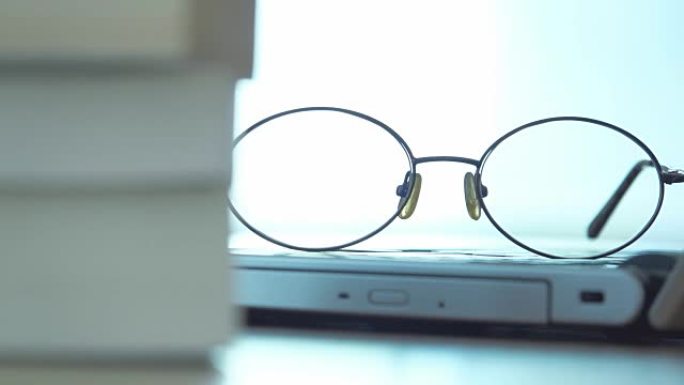 4K dolly拍摄: 空荡荡的城市办公室桌上的笔记本电脑和眼镜