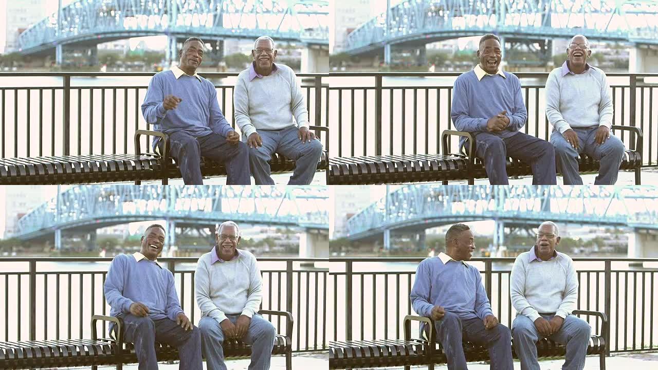 两名高级黑人在公园长椅上大笑