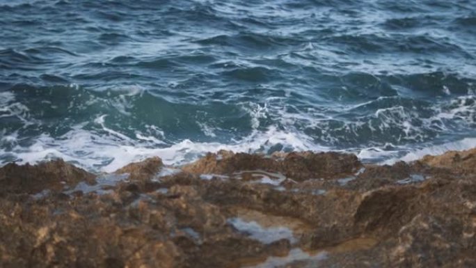 白潮撞在石头上，形成海沫。