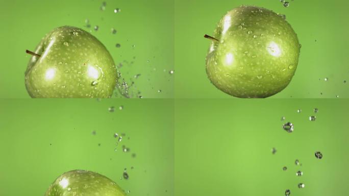 绿色背景下的绿色苹果在慢动作中的飞行