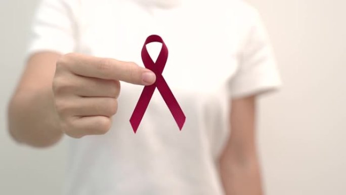 手捧红丝带，12月世界艾滋病日，多发性骨髓瘤癌症宣传月和全国红丝带周。医疗保健和世界癌症日概念