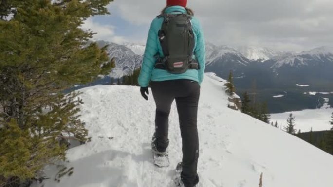 在山脊上，女人雪鞋行走的第一人称视角