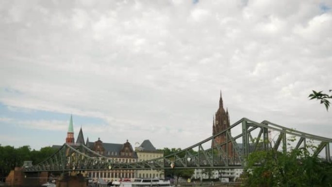 美因河畔法兰克福的人行天桥。法兰克福市美丽的历史中心，有市政厅和教堂。带有河流和走道桥的旅游城市地区