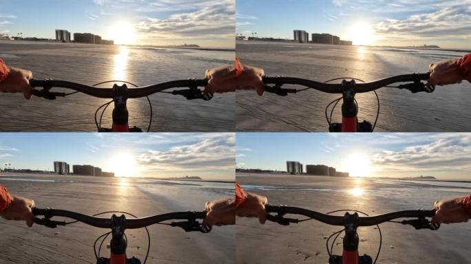 男子在空旷的海滩上骑自行车的第一人称视角