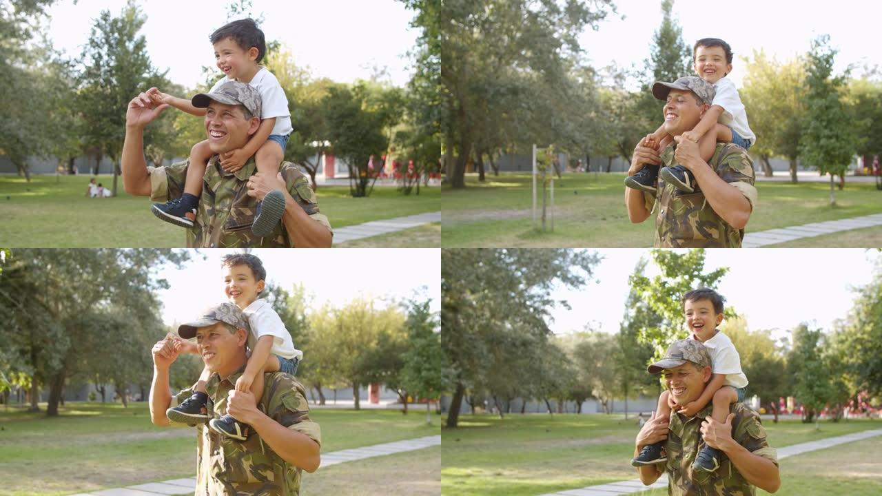 快乐可爱的小男孩骑在爸爸的肩膀上在公园里