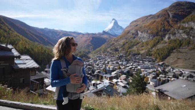 在瑞士阿尔卑斯山徒步旅行时，母亲用胸前背包背着婴儿