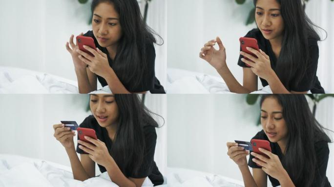 亚洲女性在床上用电话和信用卡在线购物