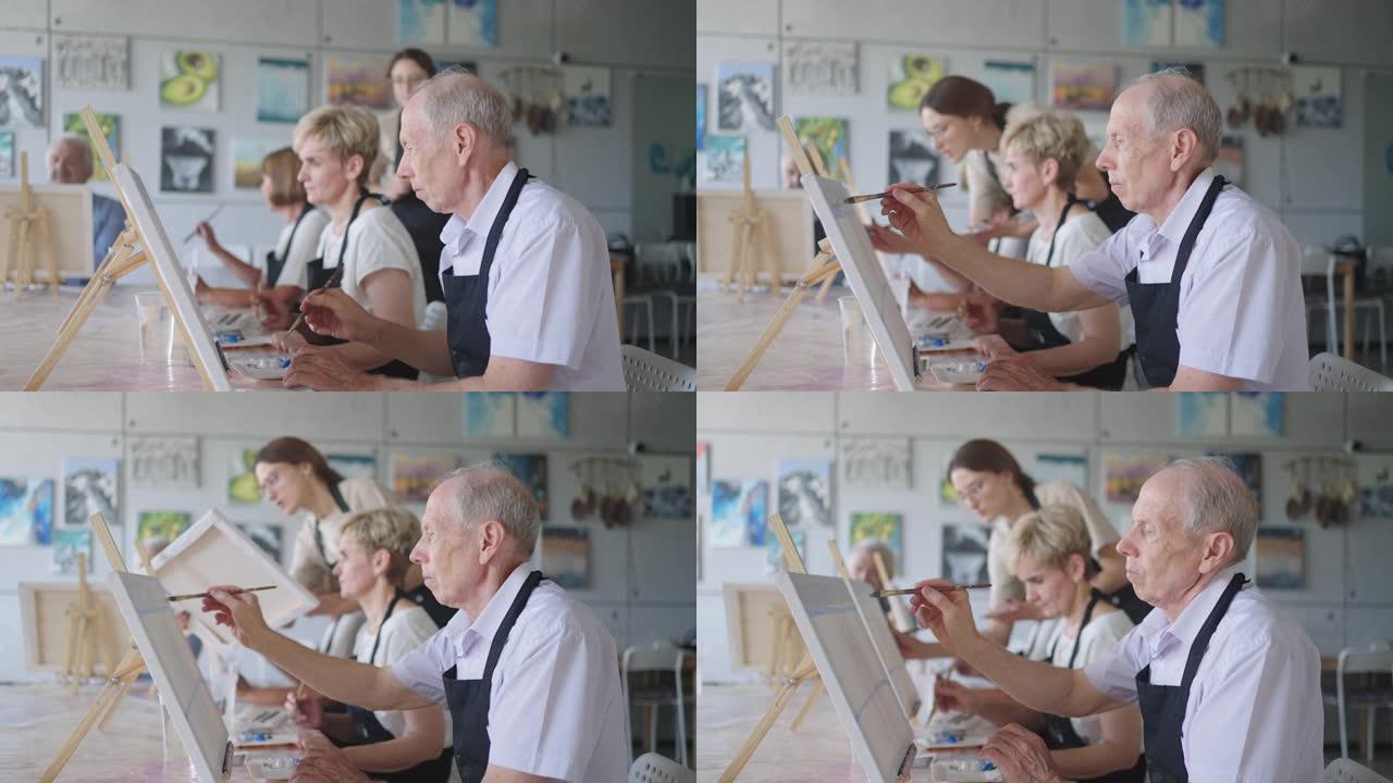 一位女老师向一位退休男子展示了如何在老年人课程中使用油漆和毛笔画画。一名高级男子为一群养老金领取者画